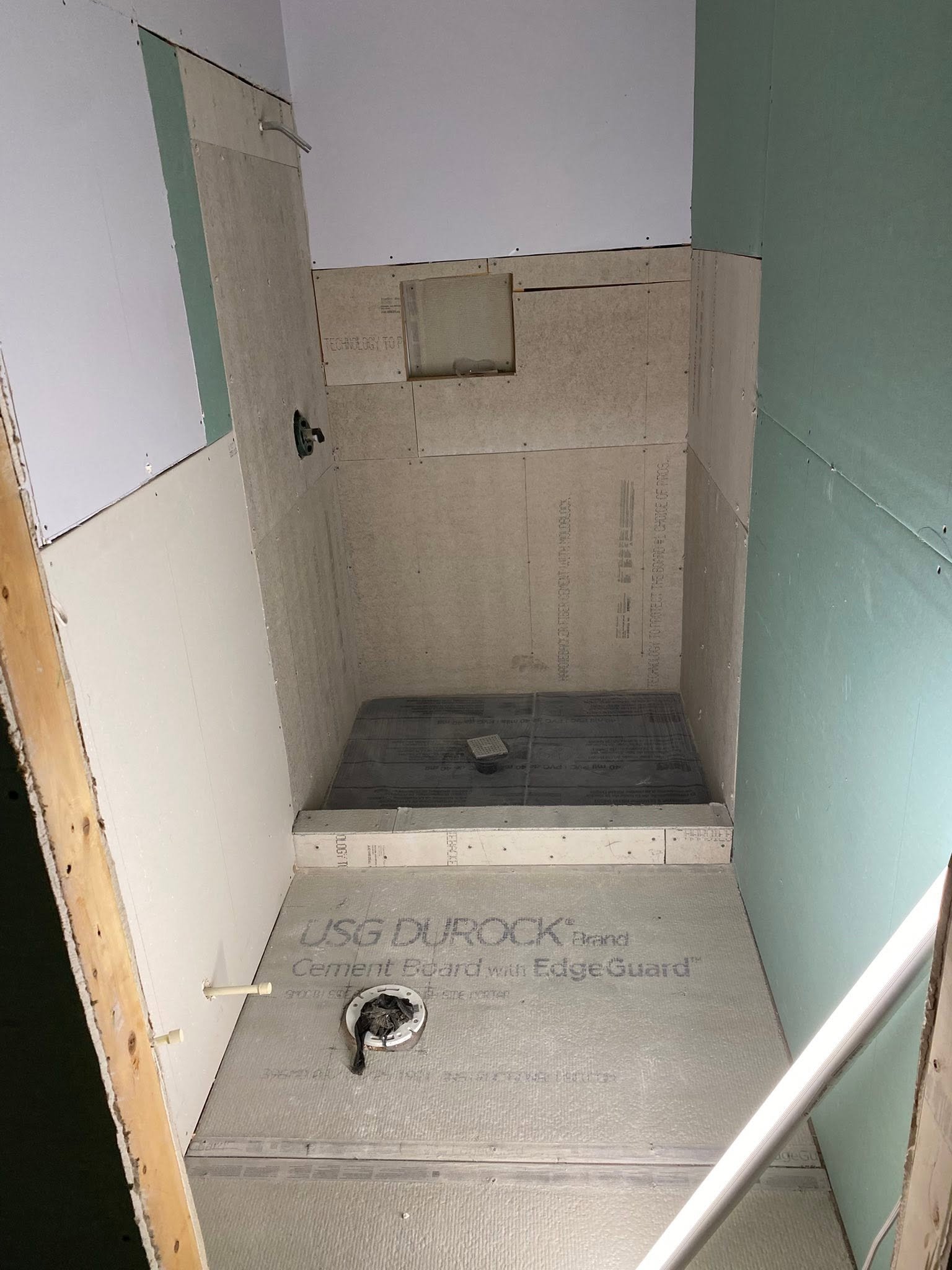 Shower rough-in complete — cement board walls, shower pan and drain stub-out ready for tile — Metro Atlanta, GA