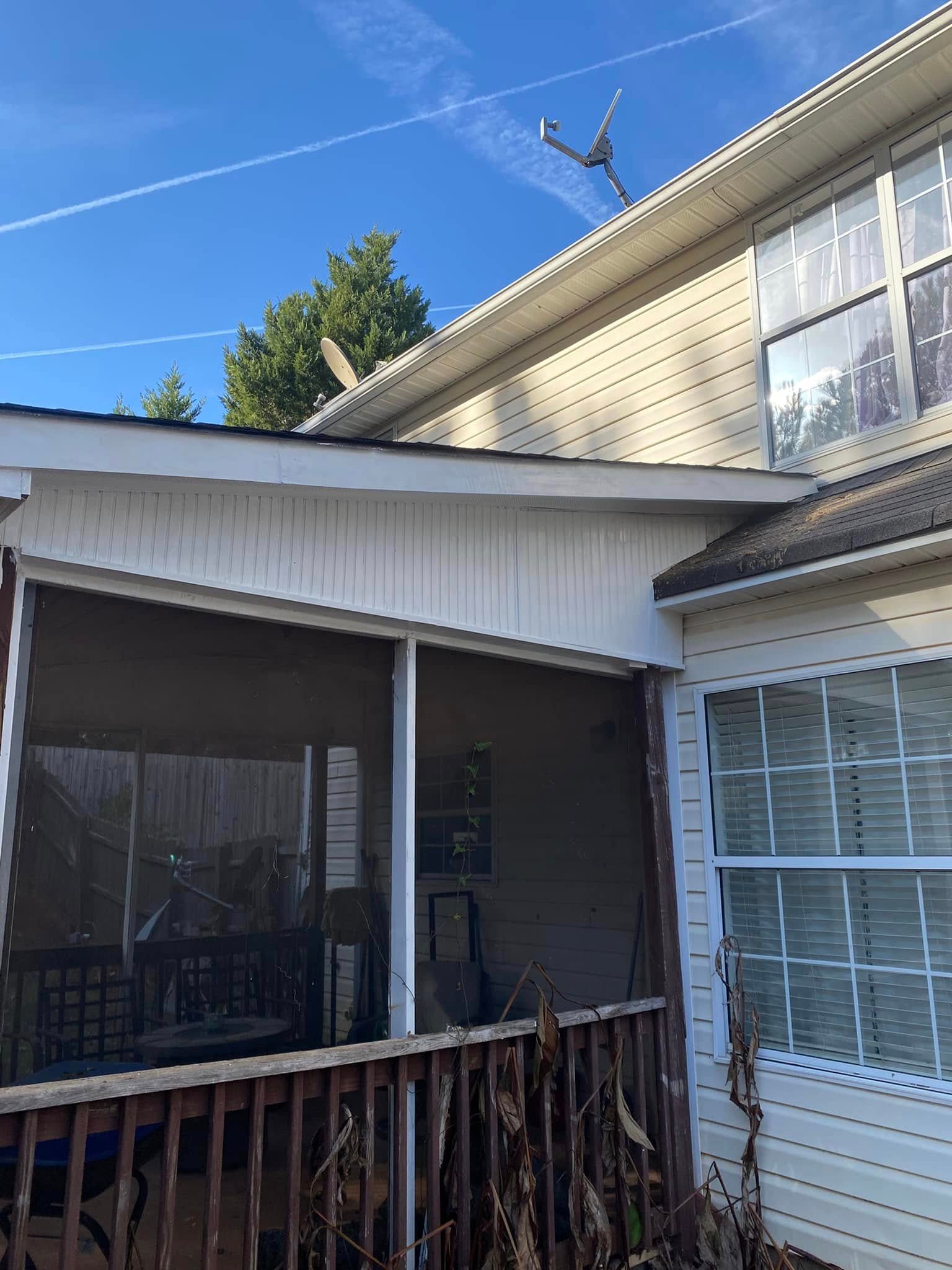 Exterior after carpentry restoration — repaired porch with new beadboard soffit, fresh paint and clean screened enclosure