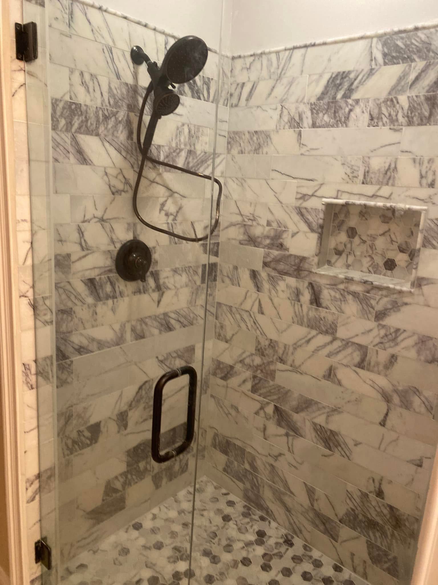 Custom marble herringbone shower with frameless glass door, hexagon penny tile floor and oil-rubbed bronze fixtures — Metro Atlanta, GA